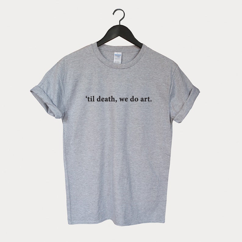 Peut inclure: Un t-shirt gris chin&eacute; avec le texte "'til death, we do art." imprim&eacute; en noir.