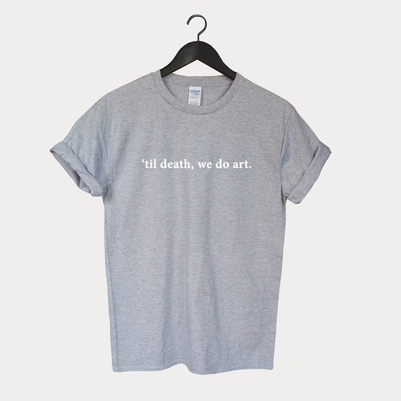 Peut inclure: Un t-shirt gris chin&eacute; avec le texte "'til death, we do art." imprim&eacute; en blanc sur le devant.