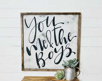 May include: A white wooden sign with black calligraphy that reads "You, Me & the Boys".