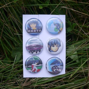 May include: Six round buttons with various images. The buttons are white with a black border. The images include a character from a video game, a spaceship, a character from a cartoon, a car, a character from a video game, and a character from a cartoon.