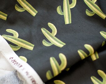 May include: Black fabric with a repeating pattern of green and yellow cactus plants. The fabric has a white label with the text "A Heart Full of Hope".
