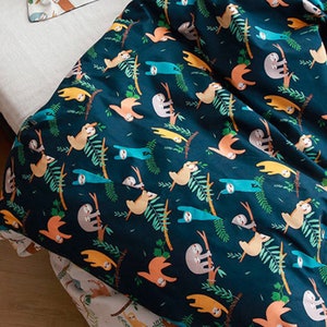 May include: A dark blue fabric with a repeating pattern of sloths hanging from branches. The sloths are in various colors, including orange, yellow, and blue. The branches are green and the background is a deep blue.