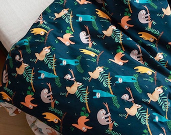 May include: A dark blue fabric with a repeating pattern of sloths hanging from branches. The sloths are in various colors, including orange, yellow, and blue. The branches are green and the background is a deep blue.