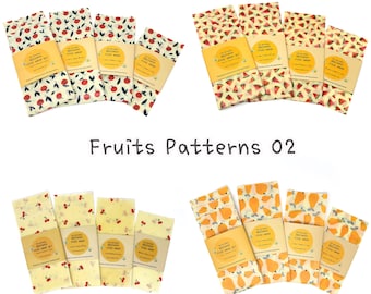 May include: Set of four beeswax food wraps with fruit patterns. The wraps feature apples, watermelon, cherries, and pears. Each wrap has a label that reads "The Natural Beeswax Food Wrap Set".
