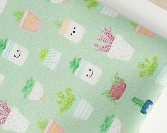 May include: Green fabric with a repeating pattern of potted plants. The plants are in various colors and styles, including cacti, succulents, and leafy plants. Some of the plants have smiling faces.