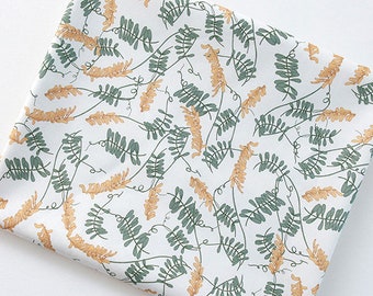 May include: White fabric with a repeating pattern of green leaves and yellow flower buds.