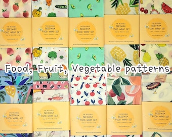 May include: A collection of reusable beeswax food wrap sets with various fruit and vegetable patterns. The sets include small, medium, and large sizes. The wraps feature designs of strawberries, avocados, pineapples, and more. The text "Food, Fruit, Vegetable patterns" is visible.