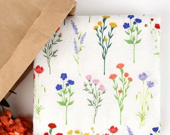 May include: White fabric with a repeating pattern of colorful wildflowers. The flowers are in shades of red, pink, yellow, blue, and green.