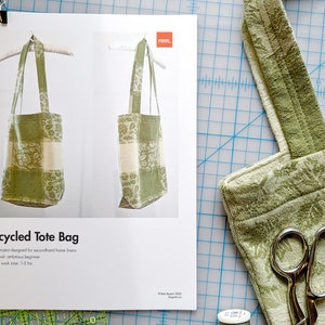 May include: A green and white tote bag made from upcycled home linens. The bag is hanging from a white hanger. The bag has a simple design with a rectangular body and two straps. The image includes the text "Upcycled Tote Bag", "Sewing project designed for secondhand home linens", "Project level: ambitious beginner", and "Estimated work time: 1-3 hrs".