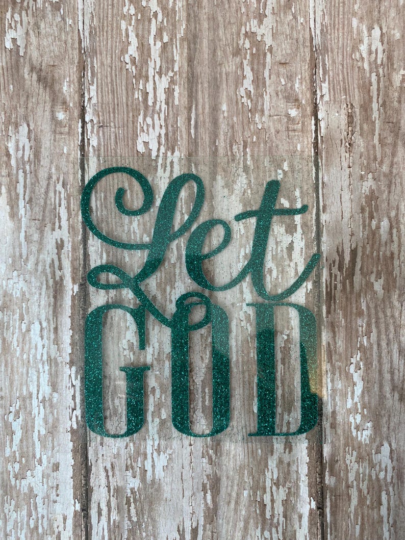 Op de afbeelding: Let God in groene glitterletters op een verweerde houten achtergrond.