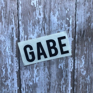 May include: A white sticker with the word "GAEB" printed in black letters.