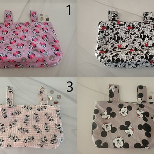May include: Four different fabric bags with Mickey Mouse and Minnie Mouse designs. The bags are pink, white, gray, and pink with black and white patterns. The bags have two handles and are made of cotton fabric.