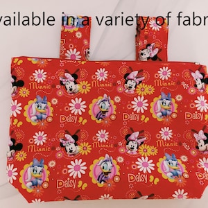 Könnte beinhalten: Rote Tragetasche mit Minnie Mouse und Daisy Duck-Motiven, mit den Texten "Minnie" und "Daisy". Die Tasche hat zwei passende Griffe und den Text "Available in a variety of fabrics" oben.