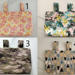 Może przedstawiać: Cztery różne materiałowe torby na kierownicę roweru z różnymi wzorami. Torby są ponumerowane od 1 do 4. Torba 1 ma wzór kwiatowy z różowymi i żółtymi różami. Torba 2 ma wzór tropikalnych liści z zielonymi i różowymi liśćmi. Torba 3 ma wzór kamuflażu z zielonym, brązowym i czarnym. Torba 4 ma wzór geometryczny z niebieskimi, żółtymi i czarnymi trójkątami.