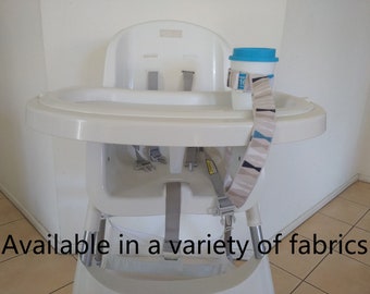 May include: White high chair with a gray fabric strap and a blue and white cup holder. The strap is available in a variety of fabrics.