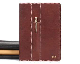 May include: A brown leather notebook with a pen holder and the name "Mia" embossed on the front.