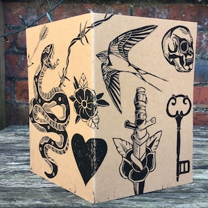 Traditionelles Tattoo Blatt Linoldruck braun natur Kraftpapier A5 Notizbuch Schlange Herz Schwalbe Rose Dagger Schlüssel Totenkopf Stacheldraht Pfeil Linolschnitt