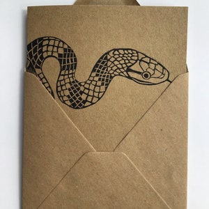 Serpiente tradicional inspirada en tatuajes linograbados, tarjeta linoimpresa, papel Kraft ecológico, manilla, blanco y negro, ilustración para amantes de los reptiles, mascota exótica