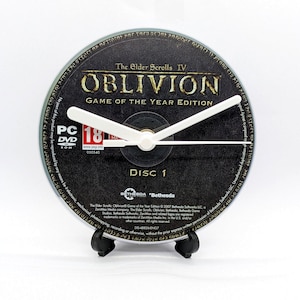 May include: A novelty clock crafted from a game disc, displaying "The Elder Scrolls IV Oblivion Game of the Year Edition." The clock has white hands and a black stand. A distinctive decorative piece for any room.