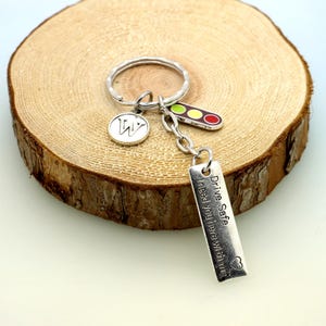 May include: Silver keyring with a traffic light charm, a letter W charm, and a tag that reads "Drive Safe I need you here with me".