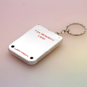 May include: A silver memory card keychain with the text "1M MEMORY CARD" and "JOYTECH" printed on it.