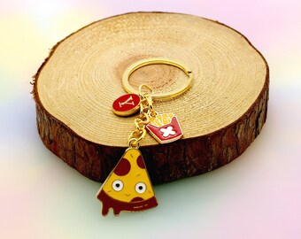 May include: Gold keychain with a pizza slice, french fries, and a letter Y charm. The pizza slice has a red and yellow enamel finish and a cartoon face. The french fries are in a red and white box. The letter Y charm is red with a gold outline.