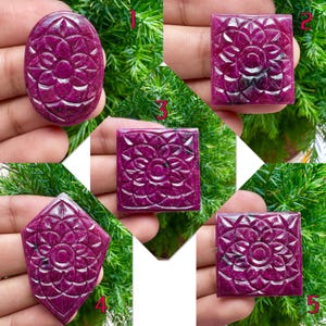 May include: Five carved ruby gemstones in various shapes: oval, square, rectangular, and diamond. Each gemstone features a floral design carved into the surface. The rubies are a deep, rich red color.