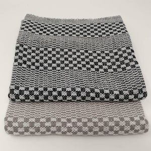May include: Two kitchen towels, one black and white and one gray and white, with a checkered pattern.