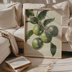 K&ouml;nnte beinhalten: Ein gerahmter Druck eines gr&uuml;nen Zitruszweigs mit Bl&auml;ttern. Die Fr&uuml;chte sind im Retro-Stil mit einer gl&auml;nzenden, Discokugel-&auml;hnlichen Textur dargestellt.