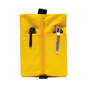 Könnte beinhalten: Eine gelbe Reißverschlusstasche mit zwei Fächern, eines mit einem schwarzen Stift und das andere mit einem silbernen Taschenmesser.