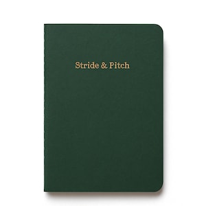 May include: A dark green notebook with the text "Stride & Pitch" in gold lettering.