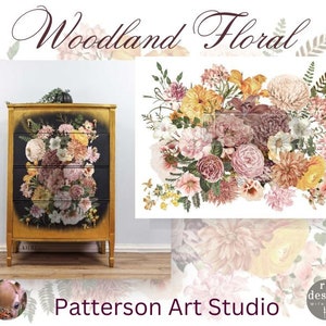 May include: A gold dresser with a black painted surface and a floral design. The dresser has four drawers and is decorated with a floral pattern in shades of pink, yellow, and green. The dresser is labeled "Patterson Art Studio" and "re-design with prima".