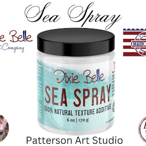 May include: A white jar with a black lid and a blue and white label. The label says "Dixie Belle Sea Spray 100% Natural Texture Additive 6 oz | 170 g".