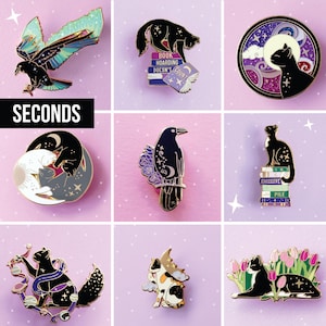 Peut inclure: Une collection de neuf pin's en émail représentant des chats noirs, des corbeaux et des thèmes célestes. Les motifs incluent des chats sur des piles de livres marqués 'Book Hoarding Doesn't Count' et 'Excessive Pile', un corbeau et des fleurs.