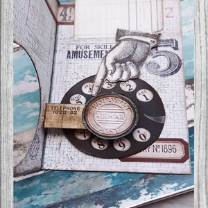 May include: A vintage-style rotary phone dial with a black and white design. The dial has numbers 0-9 and letters ABC, DEF, JKL, MNO, and VW. The dial is surrounded by a brown paper background with a grid pattern. The text "TELEPHONE 1023-32" and "AIRMAIL POST" are visible on the dial.