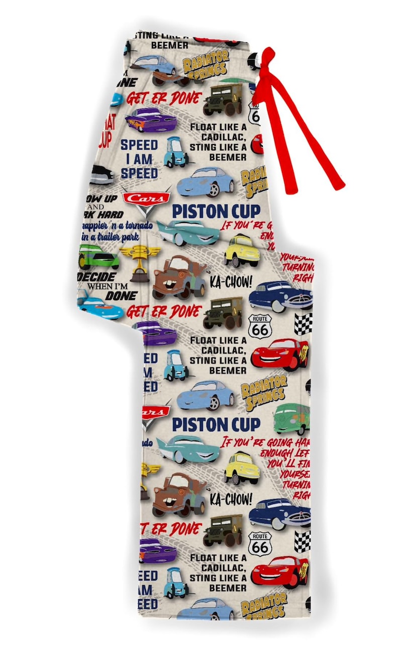 Puede incluir: Una tela blanca con un patr&oacute;n repetido de coches de la pel&iacute;cula Cars. El patr&oacute;n incluye los personajes Rayo McQueen, Mate y otros coches. La tela tambi&eacute;n incluye texto de la pel&iacute;cula, como "Get er Done", "Ka-Chow!" y "Piston Cup".