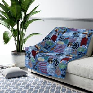 May include: A blue and white throw blanket with a repeating pattern of characters and quotes from the Guardians of the Galaxy movie franchise. The blanket features the text "I am Groot", "Dance Off Bro!" and "Guardians of the Galaxy".