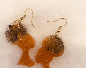 Brincos de resina com silhueta de mulher africana e penteado com coque.