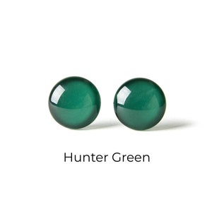 May include: A pair of hunter green round stud earrings.