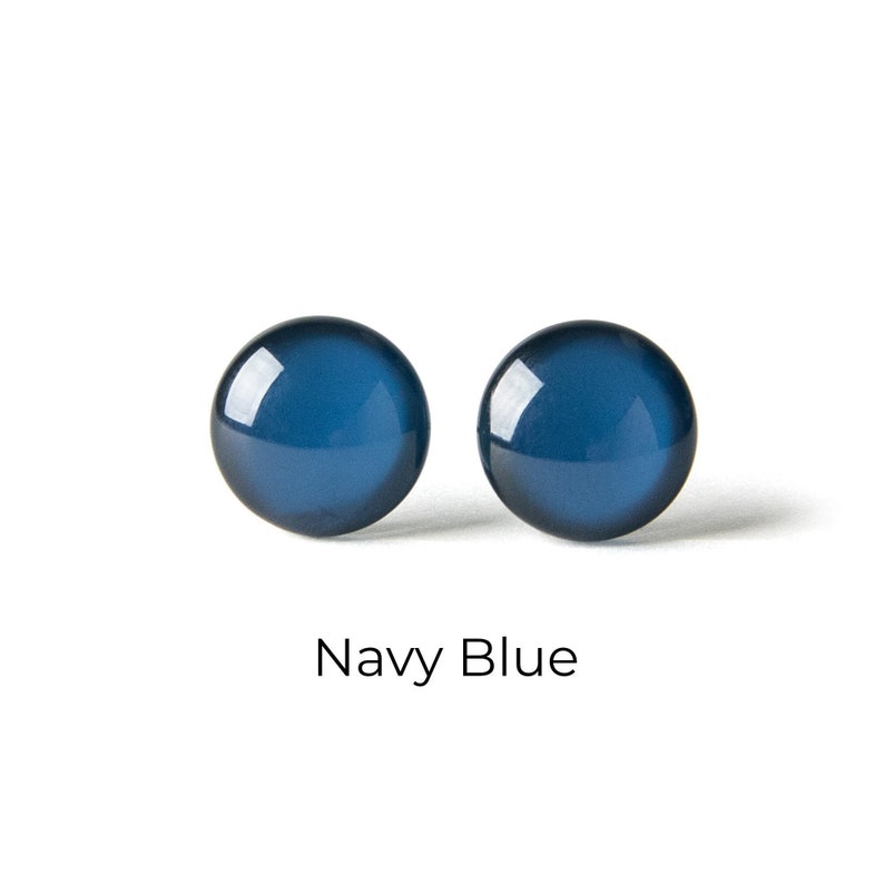 May include: A pair of round, navy blue stud earrings.