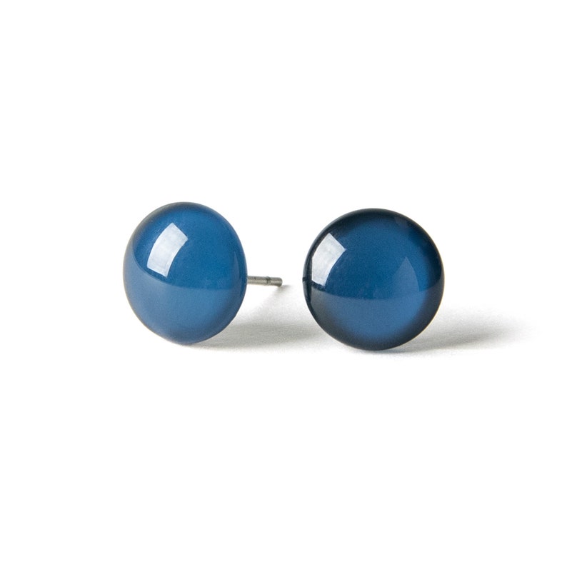 May include: A pair of blue stud earrings with a smooth, rounded surface.