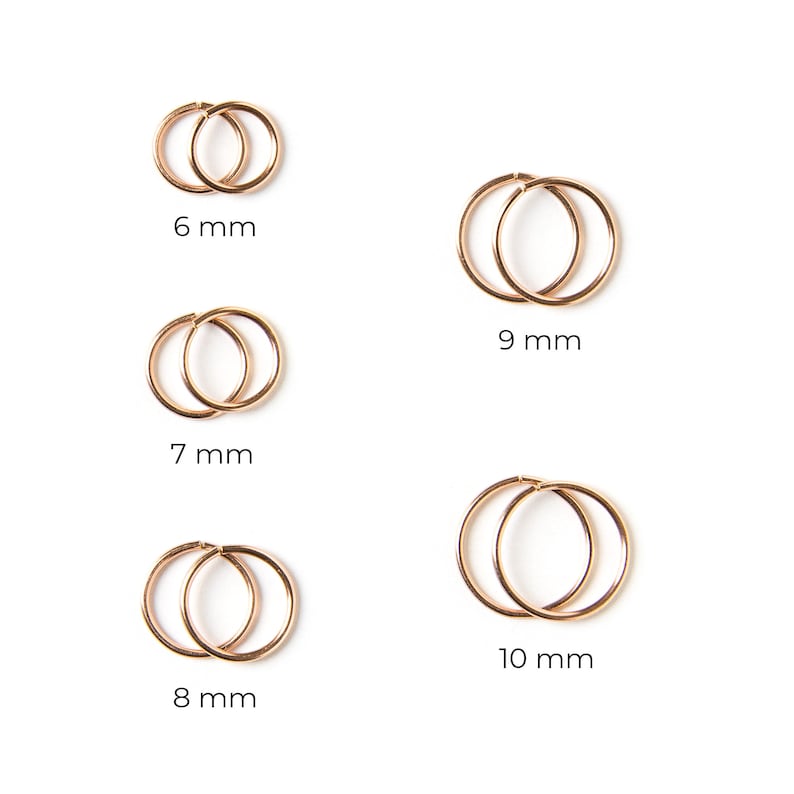 May include: A pair of rose gold hoop earrings in different sizes. The earrings are arranged in a grid pattern. The sizes of the earrings are 6 mm, 7 mm, 8 mm, 9 mm, and 10 mm.