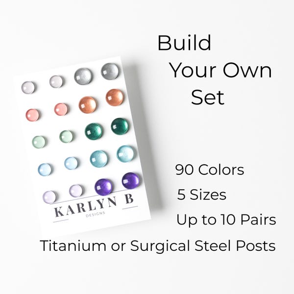 May include: A card with a variety of coloured glass beads arranged in rows. The card reads "Build Your Own Set", "90 Colours", "5 Sizes", "Up to 10 Pairs", "Titanium or Surgical Steel Posts", and "KARLYN B DESIGNS".