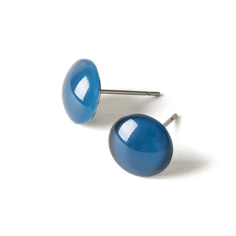 May include: A pair of blue oval stud earrings with silver posts.