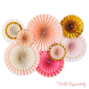 May include: A set of eight paper fan decorations in pink, peach, and gold. The fans are layered and have a variety of patterns, including polka dots, stripes, and gingham. The text "*Sold Separately" is printed at the bottom of the image.