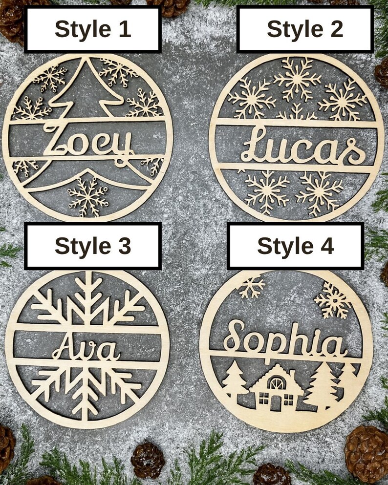 May include: Four wooden Christmas ornaments with personalized names. Style 1 features a tree design with the name "Zoey". Style 2 has snowflakes and the name "Lucas". Style 3 has a snowflake design with the name "Ava". Style 4 has a house design with the name "Sophia".