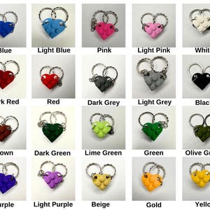 May include: A selection of heart-shaped keyrings in diverse colours, such as blue, pink, red, and green. Each keyring is constructed from interlocking blocks and has a silver-tone ring. The image includes labels with the colour names.