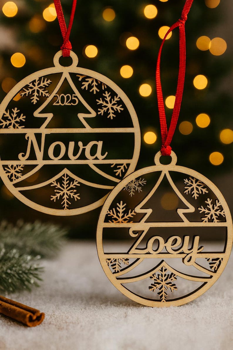 May include: Two wooden Christmas ornaments with red ribbons. One ornament says "Nova" and "2025" with a tree and snowflake design. The other ornament says "Zoey" with a tree and snowflake design.