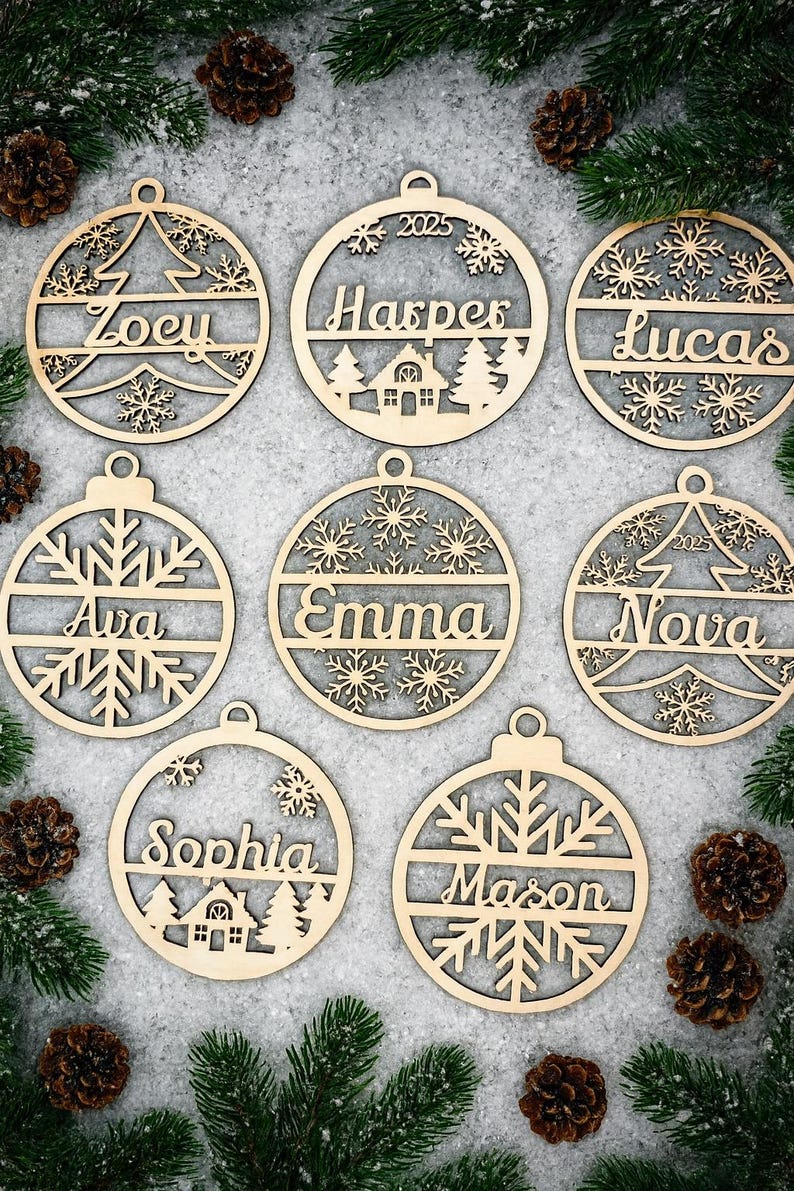 May include: Wooden Christmas ornaments with personalized names, snowflakes, and tree designs. Each ornament is circular with a loop for hanging. Names include Zoey, Harper, Lucas, Ava, Emma, Nova, Sophia, and Mason. The ornaments are surrounded by pine needles and pine cones.