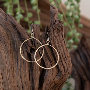 May include: A pair of gold hammered hoop earrings. The earrings are simple and elegant, and would make a great gift for any occasion.